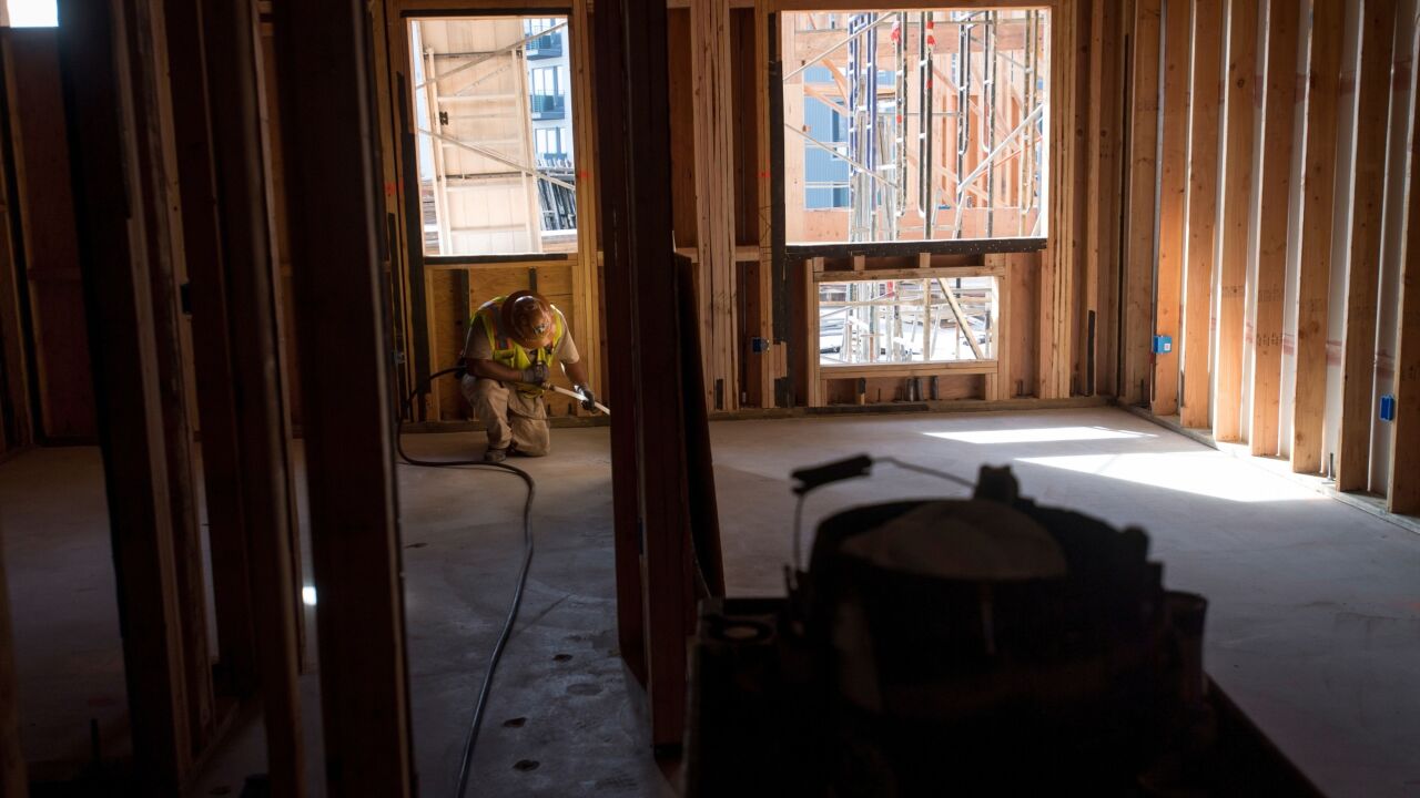 A worker runs a cable during construction on a project for affordable housing at Brooklyn Basin in Oakland, Calif.