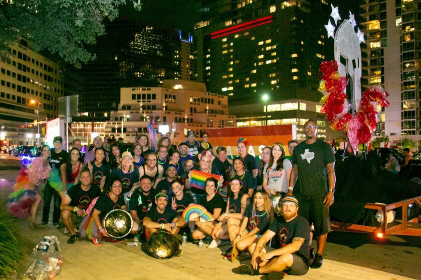 Kasasa employees participate in the 2018 Austin Pride Parade. The company logo can be seen in the top right corner.