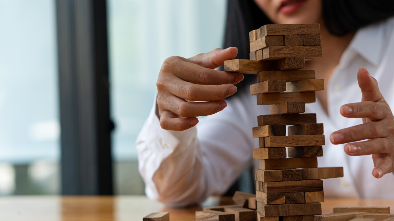 A person extracting a wooden block from a towe