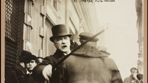 A picture of J.P. Morgan in 1910 angrily waving a cane as he walks down the street.