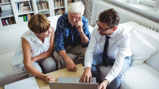 Senior couple planning their investments with financial adviser.