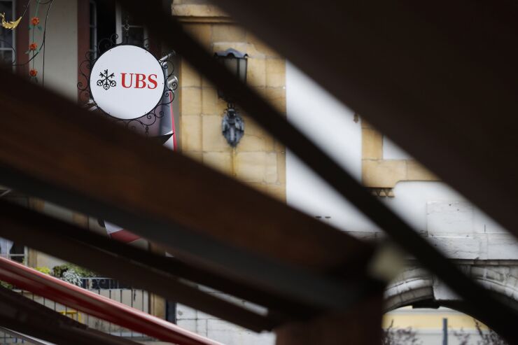 A sign hangs on display outside a UBS Group AG bank branch in Murten, Switzerland, on Wednesday, July 15, 2020. U.S. President Donald Trumps trade war with China is spurring UBSs $2.2 billion multi-strategy hedge fund to make its biggest push yet into the Asian nation.
