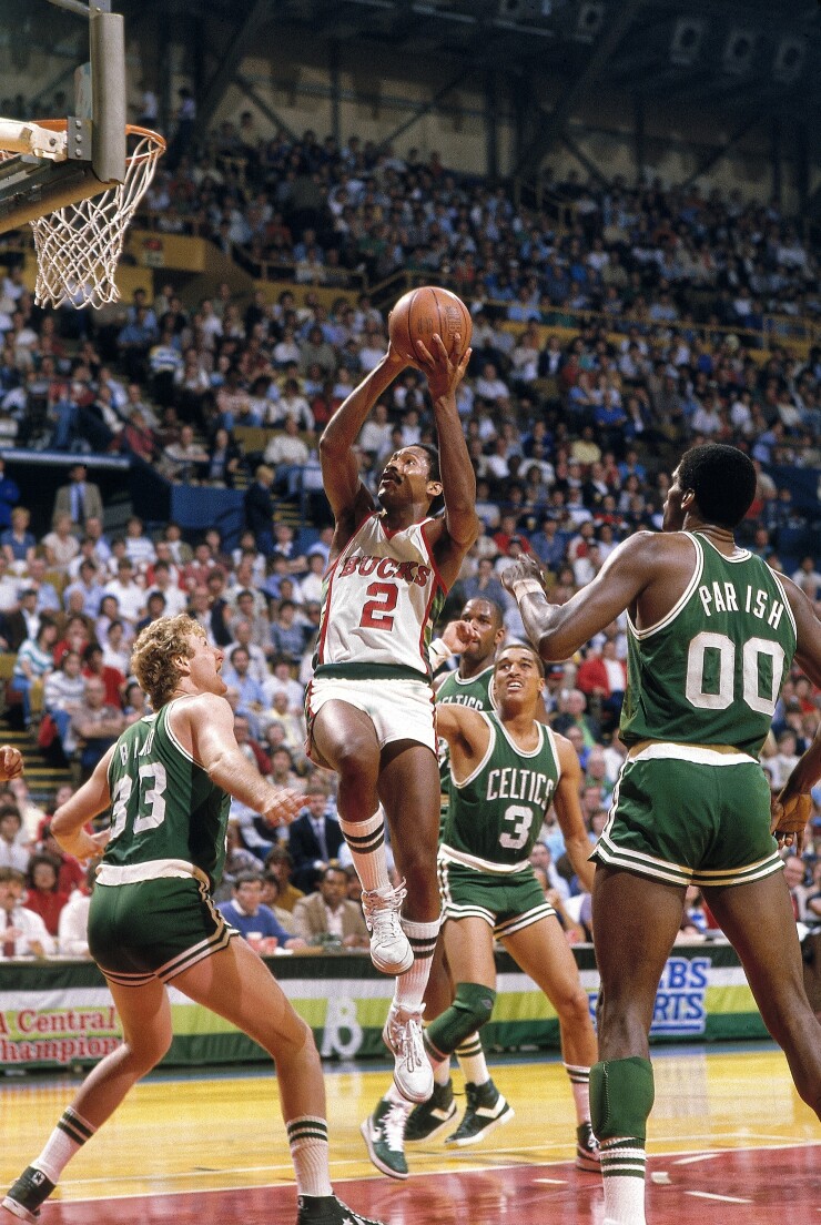 Milwaukee Bucks small forward and shooting guard Junior Bridgeman drove to the rim in a 1984 playoff game against Larry Bird, Dennis Johnson and Robert Parish and the Boston Celtics at the MECCA Arena in Milwaukee.