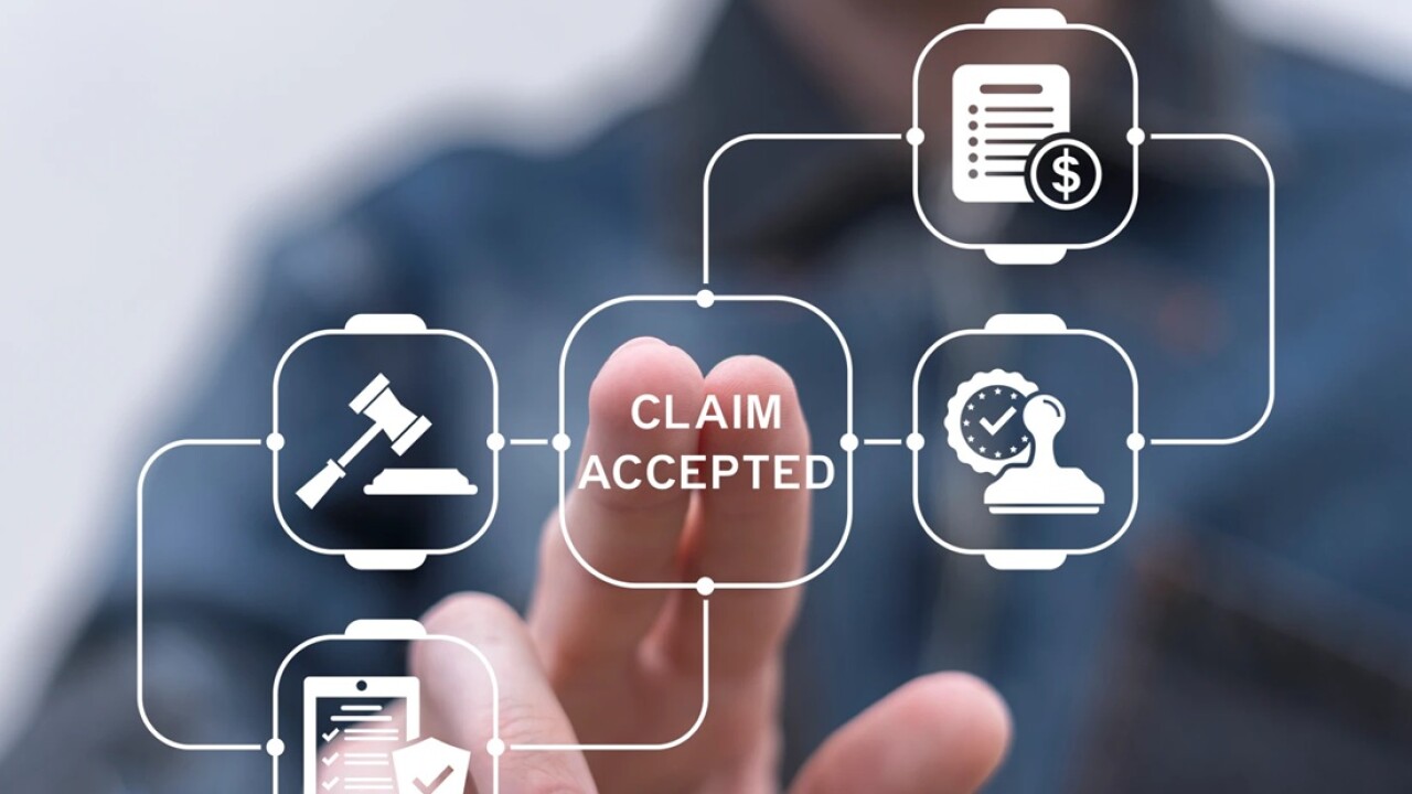 Person's fingers touching a button that says claim accepted.