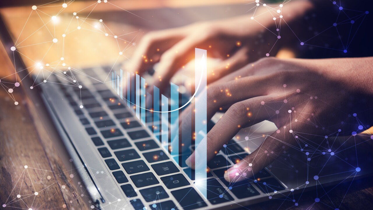A person using a laptop keyboard with a holographic chart above.