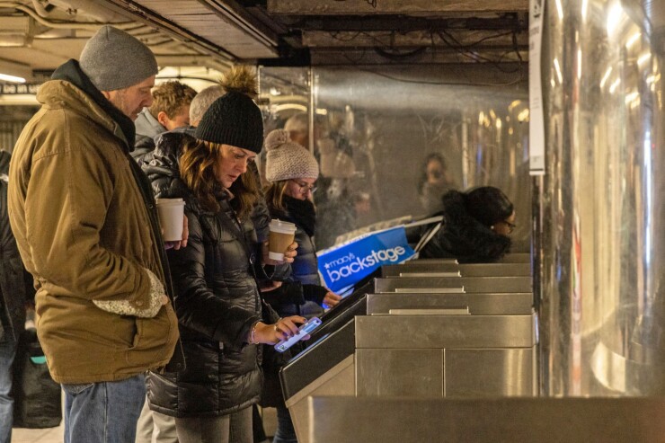New York City Subway patrons pay fares.