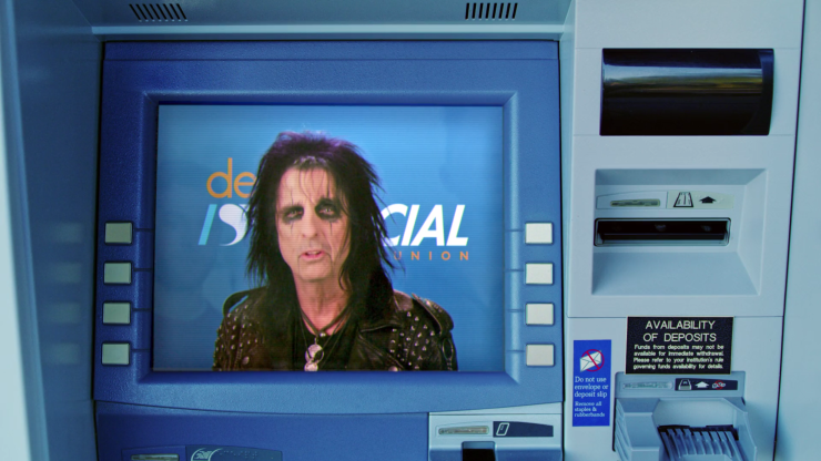 A shot from Desert Financial Credit Union's commercial featuring Alice Cooper. The legendary rocker is seen here pictured inside the credit union's ATM, informing members of the name change from Desert Schools to Desert Financial.