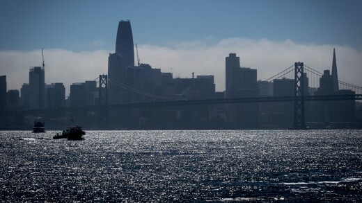 A boat passes in front of the San Francisco skyline as seen from the Port of Oakland.