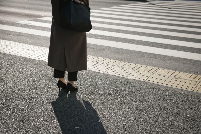 A pedestrian waits at a crossing in Shinjuku district in Tokyo, Japan on Monday, March 7, 2022. Japan’s decision to extend the duration of semi-emergency virus restrictions in Tokyo and 17 other prefectures will put further pressure on an economy that some analysts say will contract this quarter. Photographer: Noriko Hayashi/Bloomberg