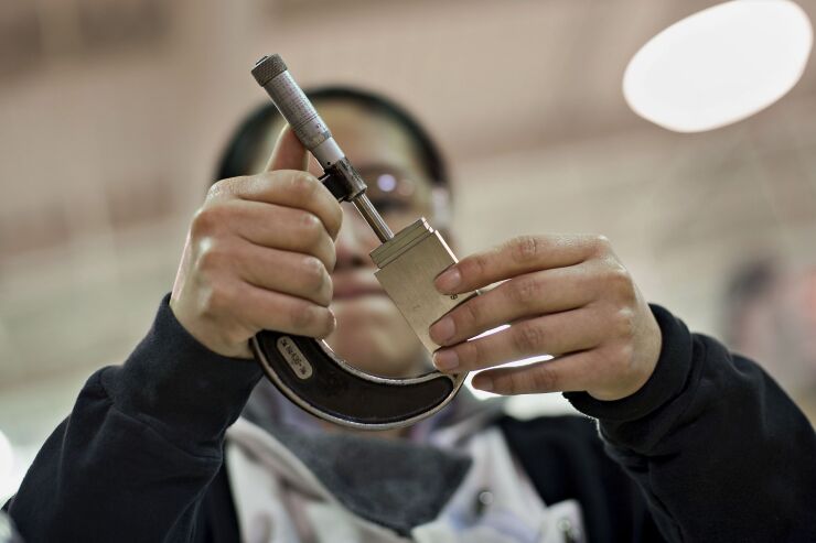Student Denise Esparza uses a micrometer to take a measurement during a Reading Blueprints and Quality Assurance class at the manufacturing technologies lab of the Richard J. Daley College in Chicago, Illinois, U.S., on Thursday, April 24, 2014. It is a community college in the City Colleges of Chicago system.