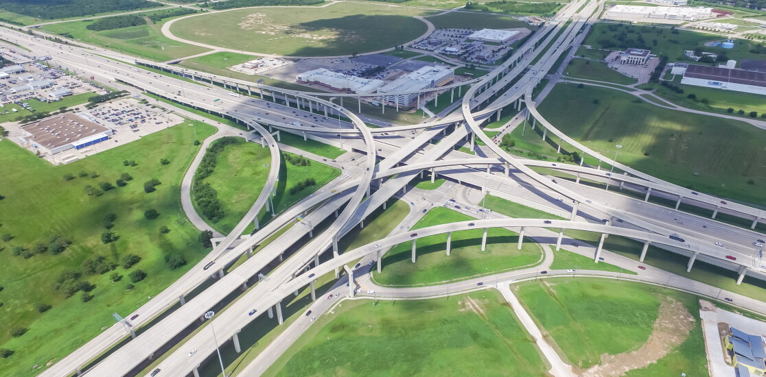 Panorama vertical aerial Interstate 10 or Katy freeway massive intersection, stack interchange, elevated road junction overpass cloud blue sky. Top view metropolitan area of Katy, Texas, USA