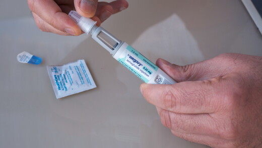 Man's hands holding Wegovy GLP-1 injection