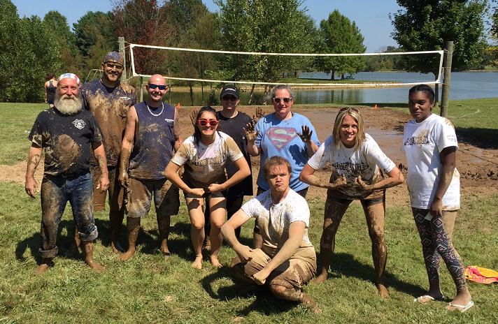 Jack Henry & Associates Inc. employees after a muddy game of volleyball.