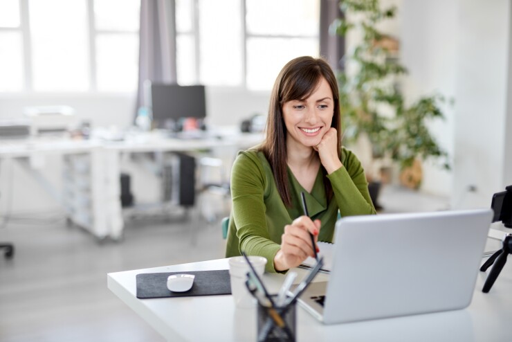 Woman looking at laptop working at desk