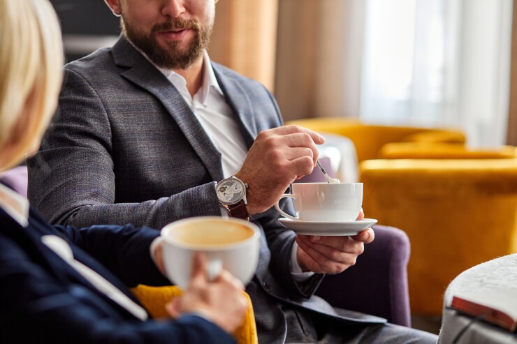 Two colleagues have coffee together.