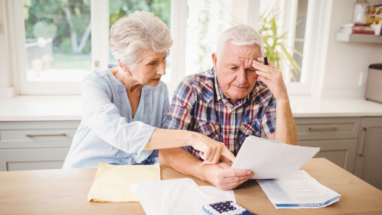 Worried senior couple checking their bills