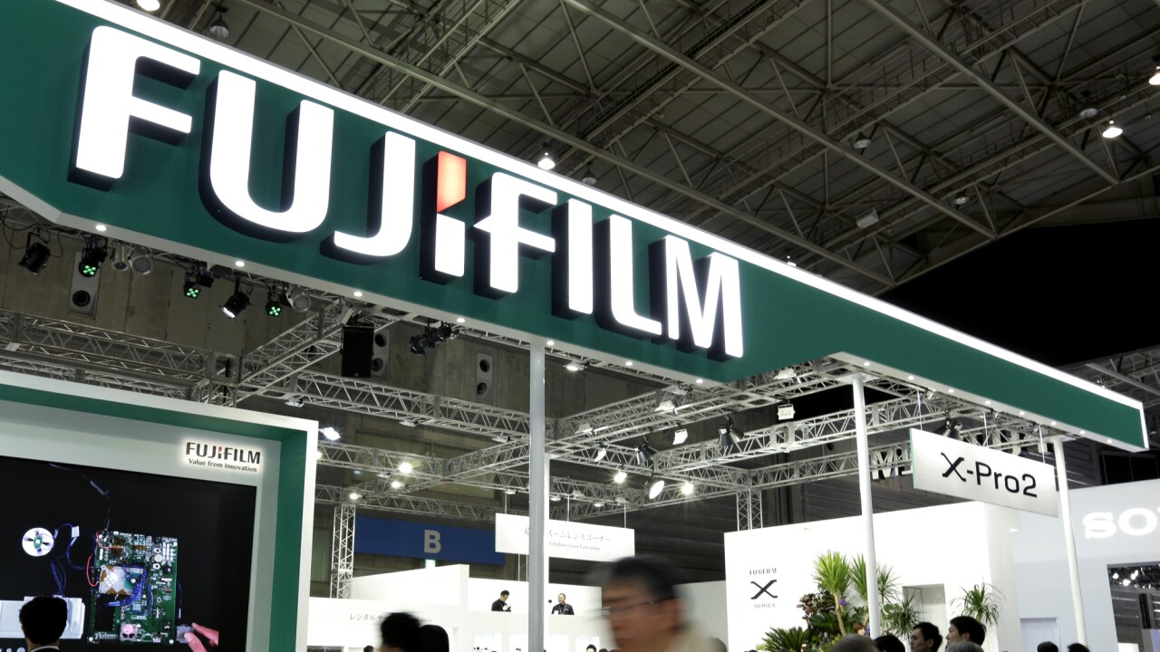 Attendees walk past the Fujifilm Holdings Corp. booth at the CP+ Camera and Photo Imaging Show in Yokohama, Kanagawa Prefecture, Japan.