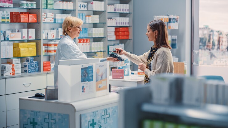 Woman getting medication from pharmacist at pharmacy counter