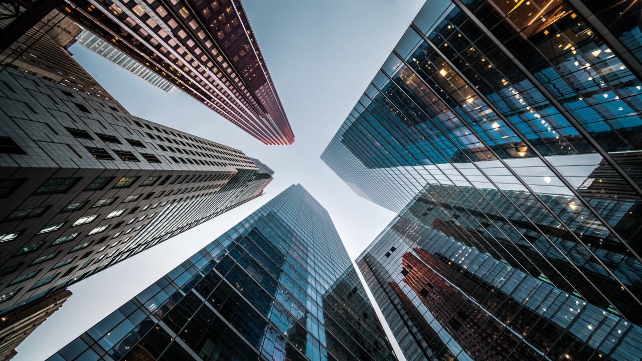 Looking up at high rise office buildings against a blue sky