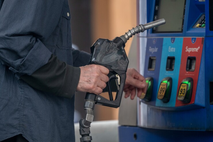 A driver refuels a vehicle with unleaded gasoline at a Mobil gas station in New York