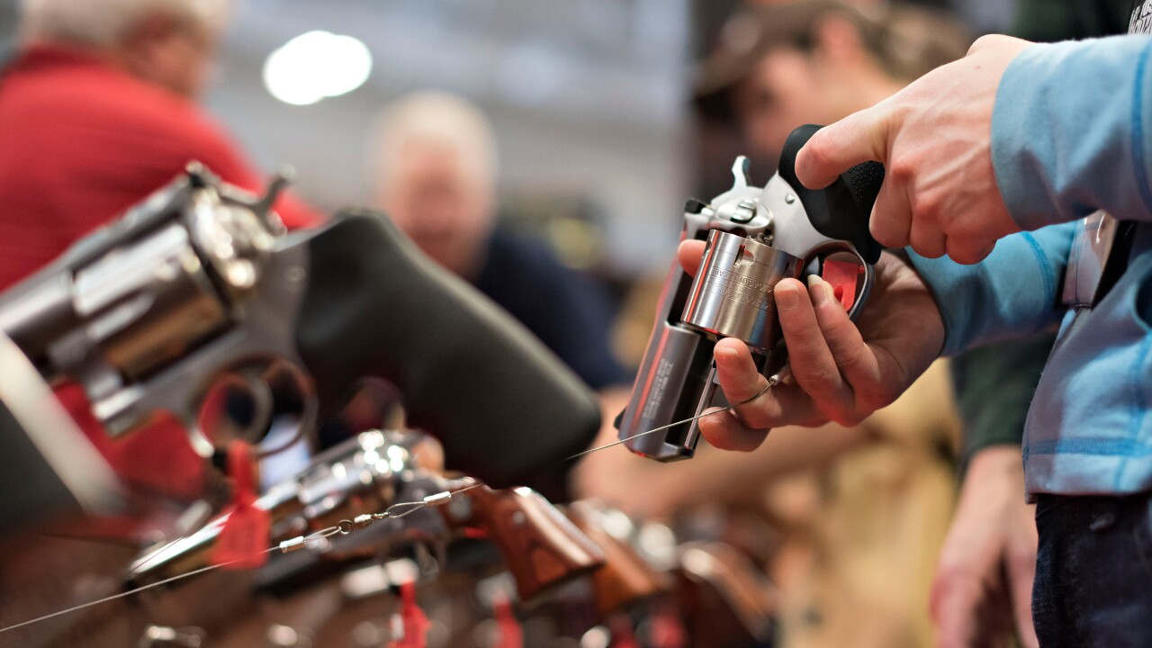 An attendee handles a revolver in the Sturm, Ruger & Co. booth on the exhibition floor of the National Rifle Association Annual Meetings and Exhibits in Nashville, Tennessee.