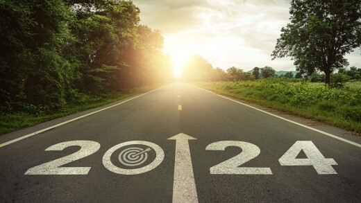 Goals, targets in New year 2024 or straightforward concept. Text 2024 and dartboard with dart icon on the road in the middle of asphalt road at sunset. Life, business planning, challenge, strategies.