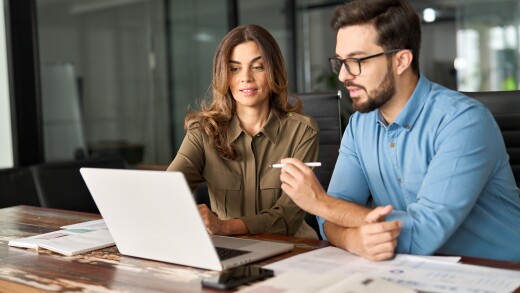 Two employees working on computer together