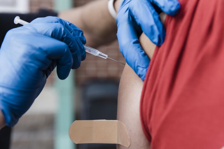 A healthcare worker administers a dose of the Covid-19 vaccine. Photographer: Angus Mordant/Bloomberg