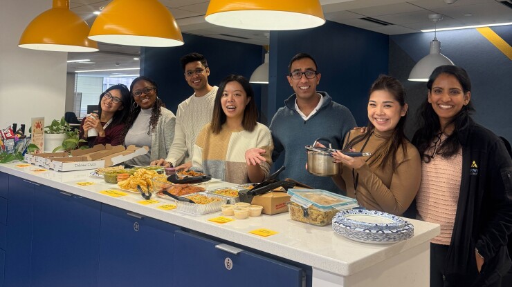 MPOWER Financing employees stand behind a counter covered in food.