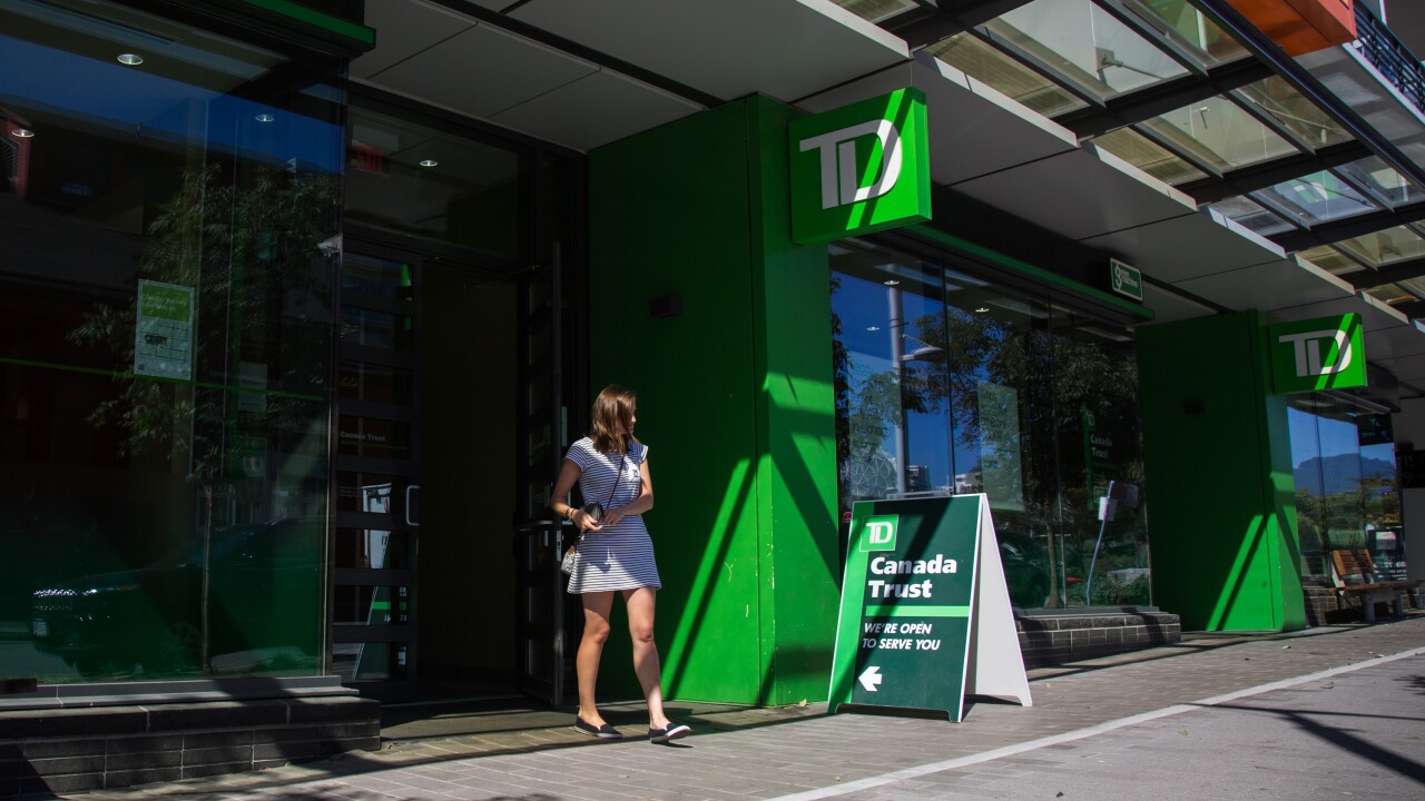 A customer exits a Toronto-Dominion Canada Trust bank branch in Vancouver.