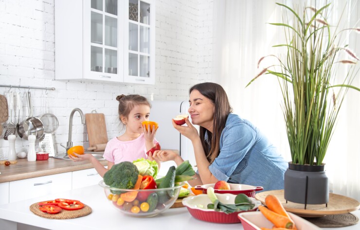 Mom and daughter in kitchen with fruits and vegetables, healthy eating
