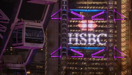 The HSBC headquarters building stands illuminated behind the Hong Kong Observation Wheel.