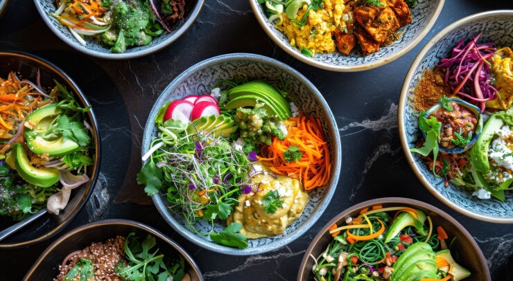 Bowls of salad on a black granite countertop.