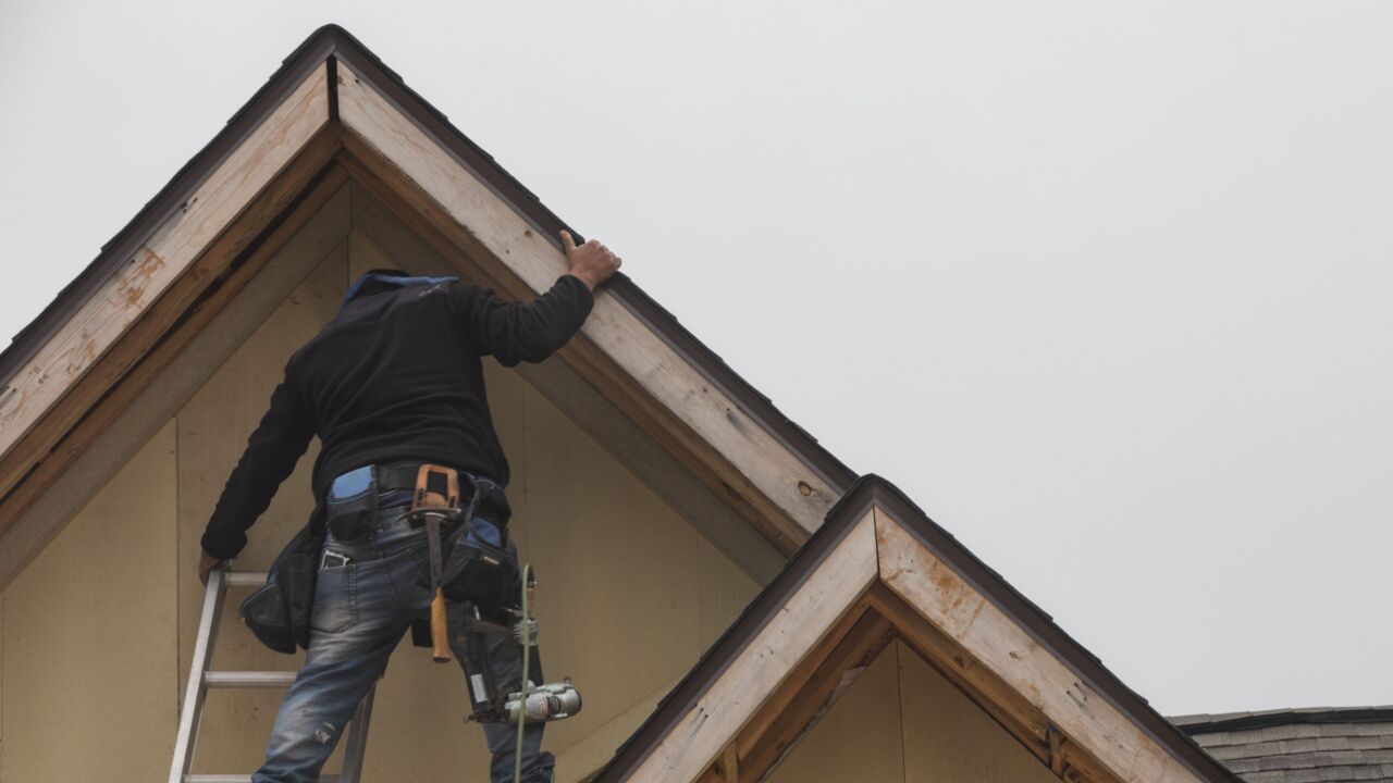 A construction worker applies trim to the roof of a new home in Foley, Alabama, US, on Wednesday, Dec. 21, 2022. New US home construction continued to decline in November and permits plunged as high borrowing costs paired with widespread inflation eroded housing affordability and demand. Photographer: Micah Green/Bloomberg