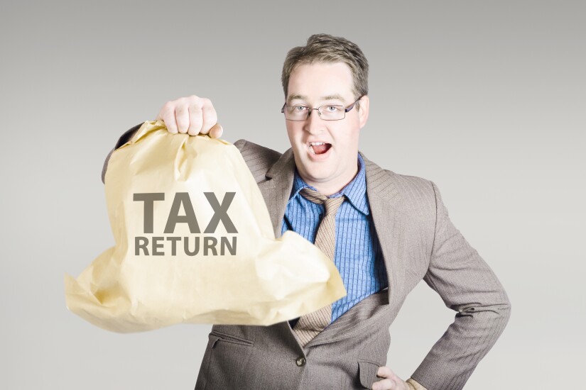 Accountant holding a large tax return refund bag