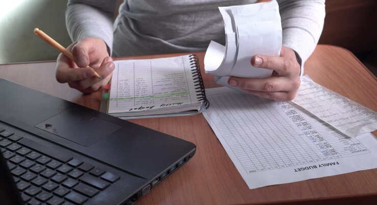 Sad woman with unpaid bills has many debts. Unemployment and per