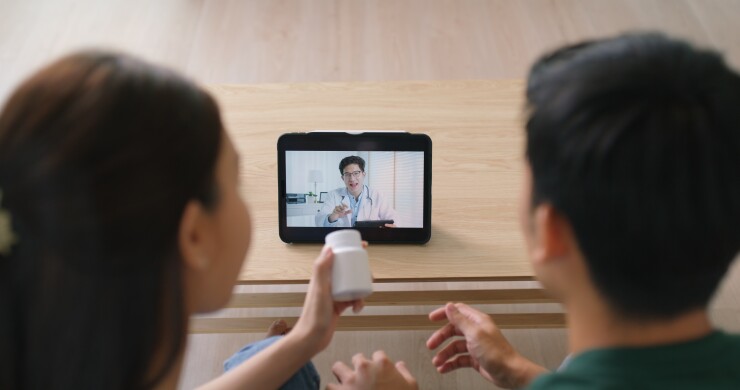 A couple speaks with a medical professional on a mobile device.