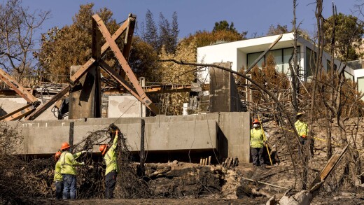 Utility workers remove power equipment after the Palisades wildfire in Los Angeles.