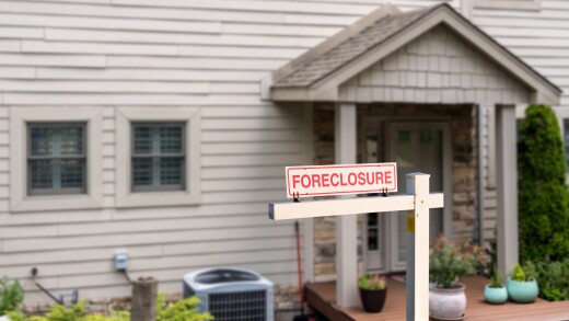 Mockup of foreclosure sign in front of modern townhome due to recession and pandemic