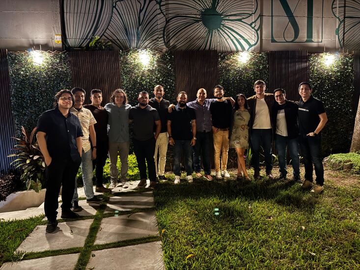 Group of people standing in a grassy courtyard at night