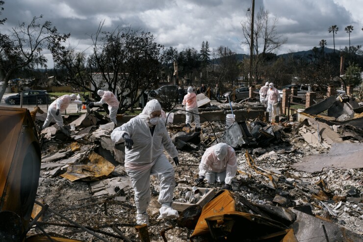 Searchers look for valuables in rubble