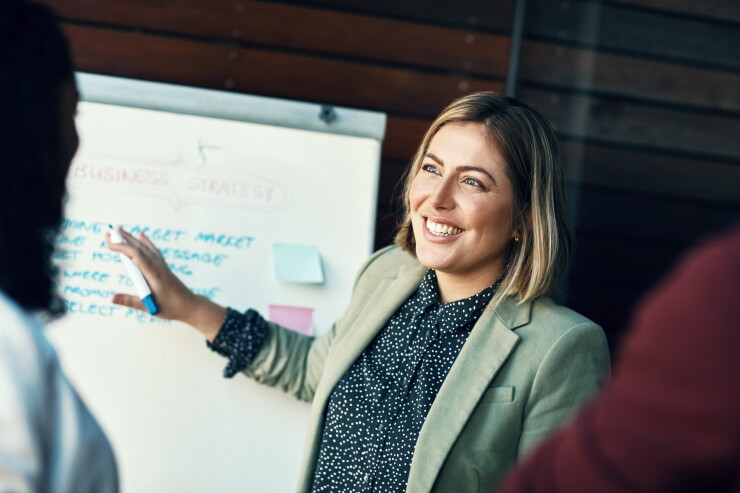 Presentation whiteboard, audience and happy woman planning, coaching and present strategy, ideas or office plan. Sales workshop, project management and team leader, boss or person speaking to group