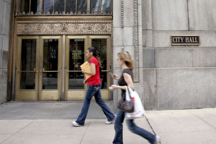 Pedestrians pass City Hall in Chicago, Illinois, U.S., on Monday, Aug. 17, 2009.