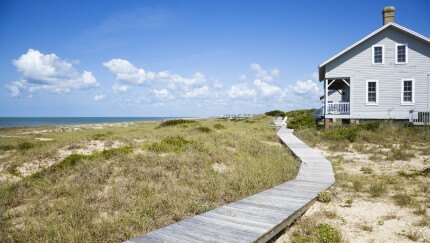 Beachfront house with wooden walkway.