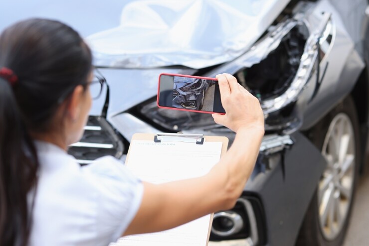Claims adjuster using a mobile device to capture auto damage.