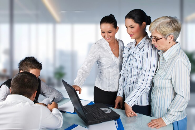 Group of employees, women standing, men sitting