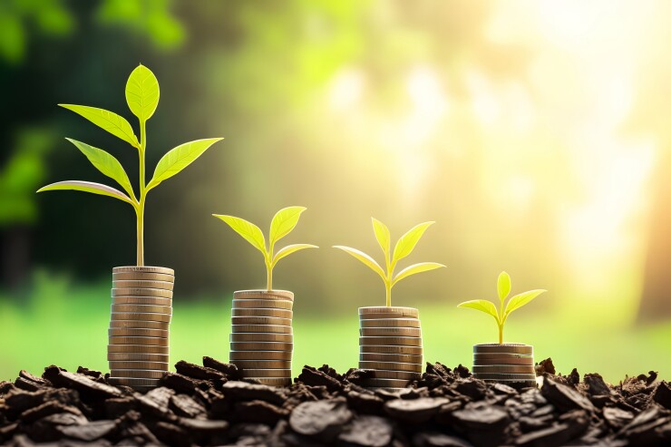 Plant growing on top of coins for investment and retirement or education concept