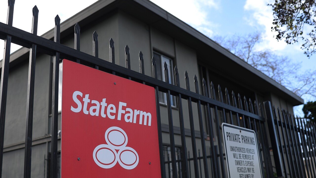 A State Farm sign on a fence.