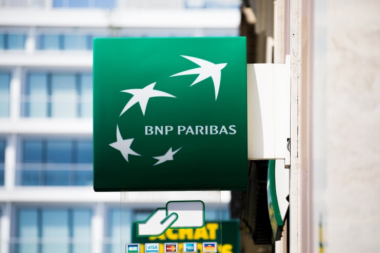 A BNP Paribas logo sits on a sign outside a bank branch in Paris.