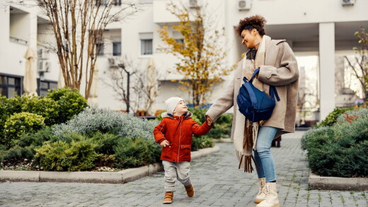 Mom and son walking to daycare, school, smiling